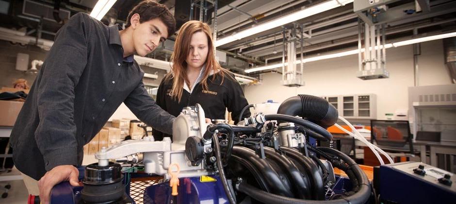 男女学生一起研究赛车的发动机
