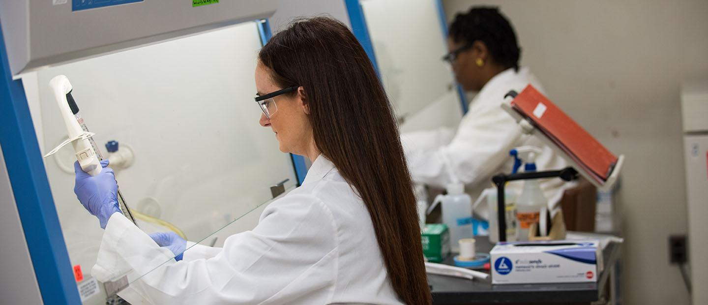 两个穿着白大褂的女人在实验室里使用设备