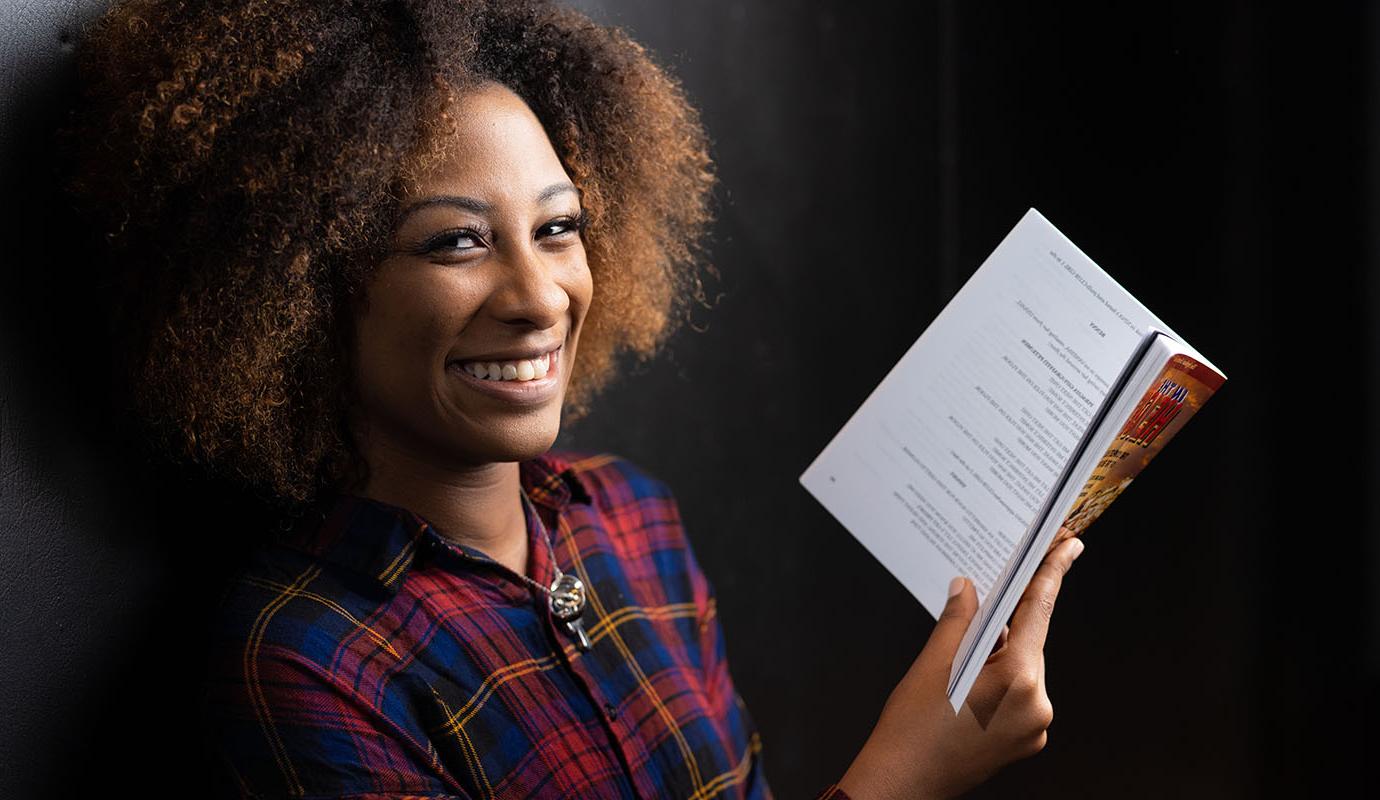 Student smiling holding book