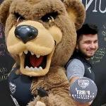 埃内斯托Duran-Gutierrez, 拿着第一代韦德体育app官网的按钮, 与棕熊吉祥物合影.